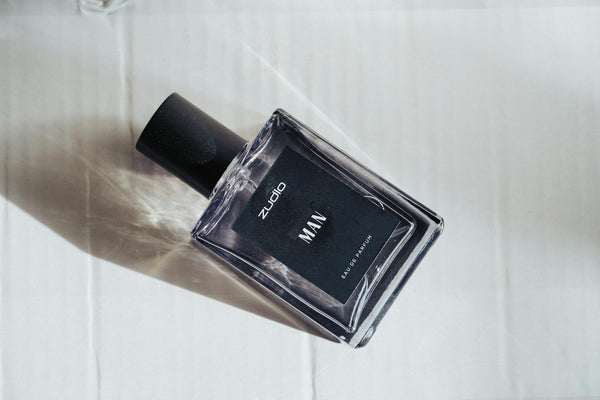 Long-lasting perfume for men displayed on dark wood surface with warm editorial lighting