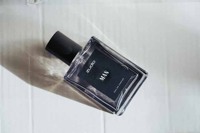 Long-lasting perfume for men displayed on dark wood surface with warm editorial lighting